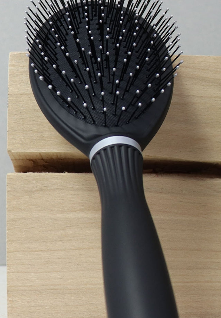 Schwarze Haarbürste auf Holzblock