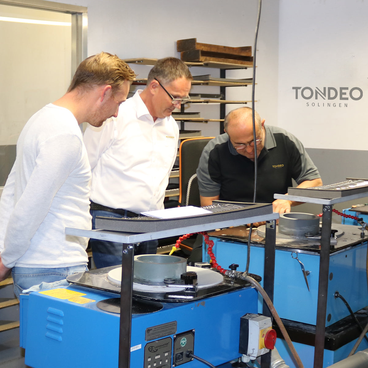 Drei Männer prüfen Friseurscheren-Produktion