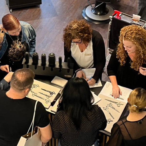 Friseure begutachten hochwertige Friseurscheren