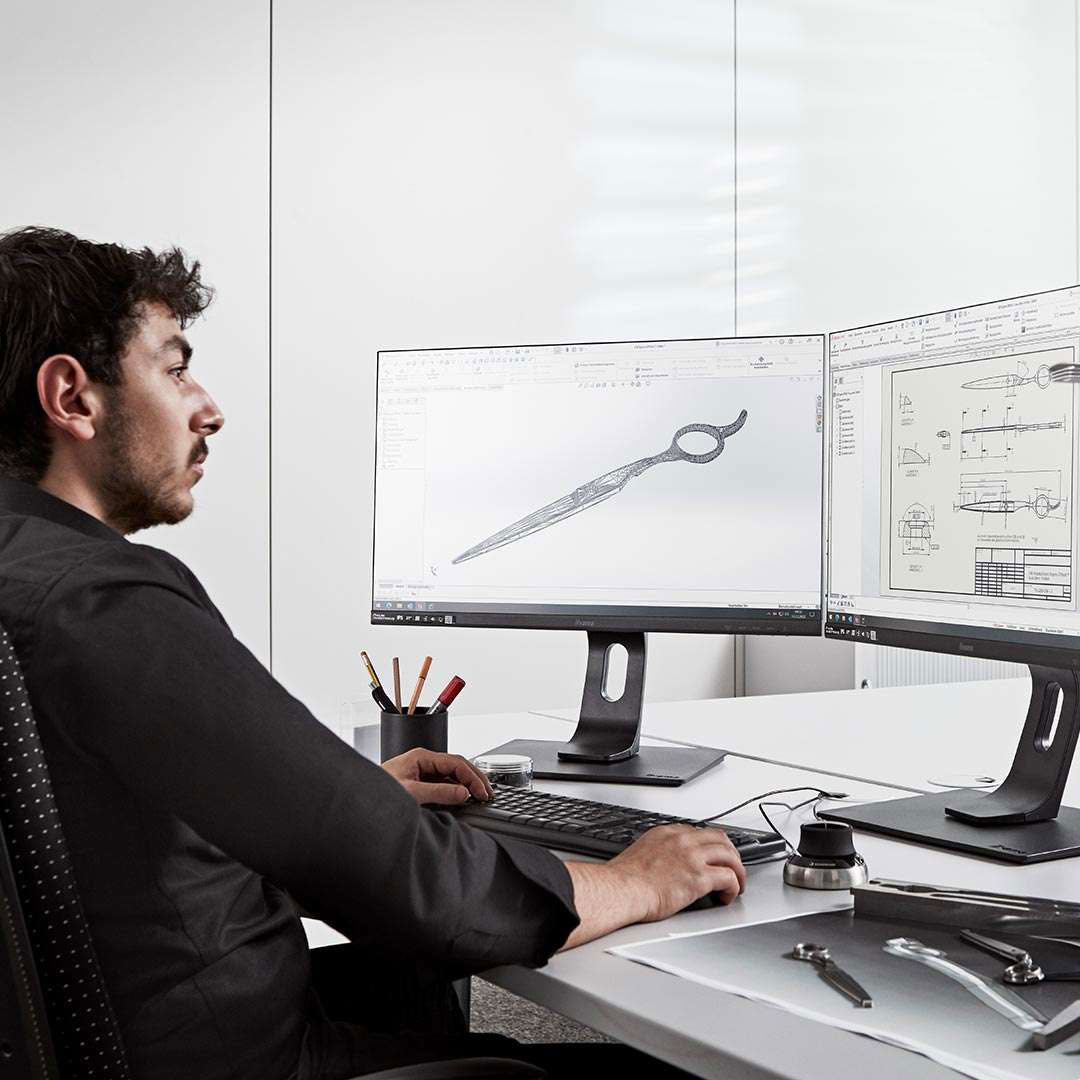 Mann entwirft Friseurschere am Computer