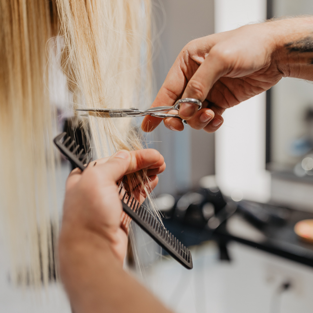 Friseurschere schneidet blondes Haar