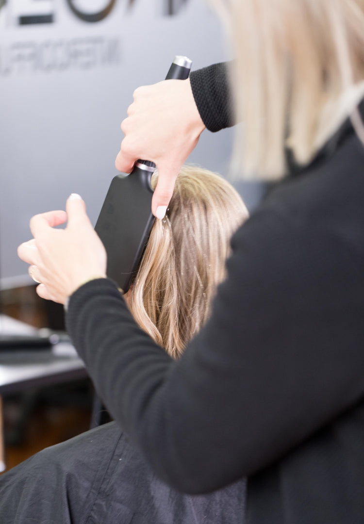 Friseurin schneidet Haare mit Schere