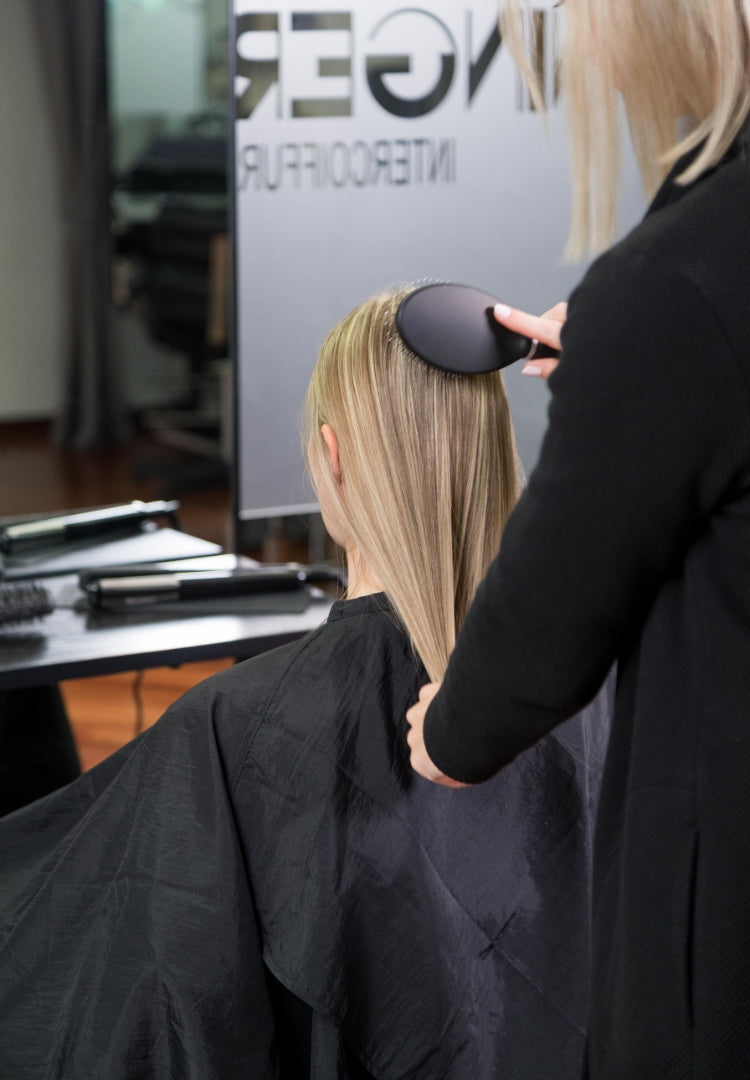 Friseurin bürstet blonde Haare
