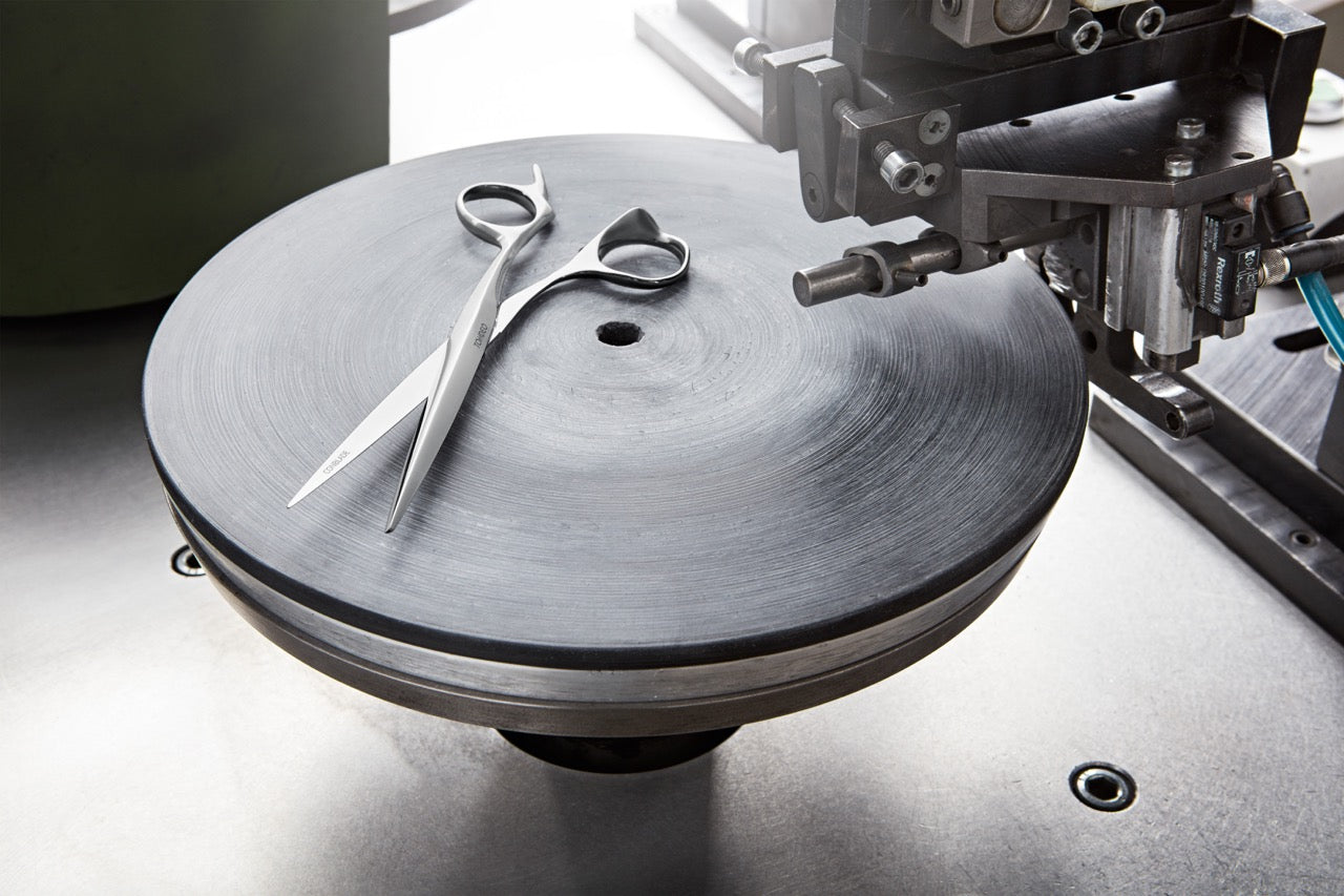 Friseurschere auf Schleifmaschine liegend