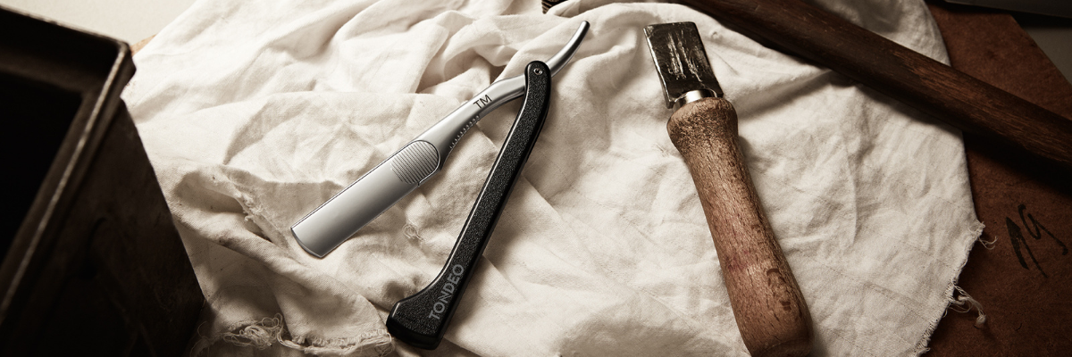 Friseurschere und Rasiermesser auf Stoff