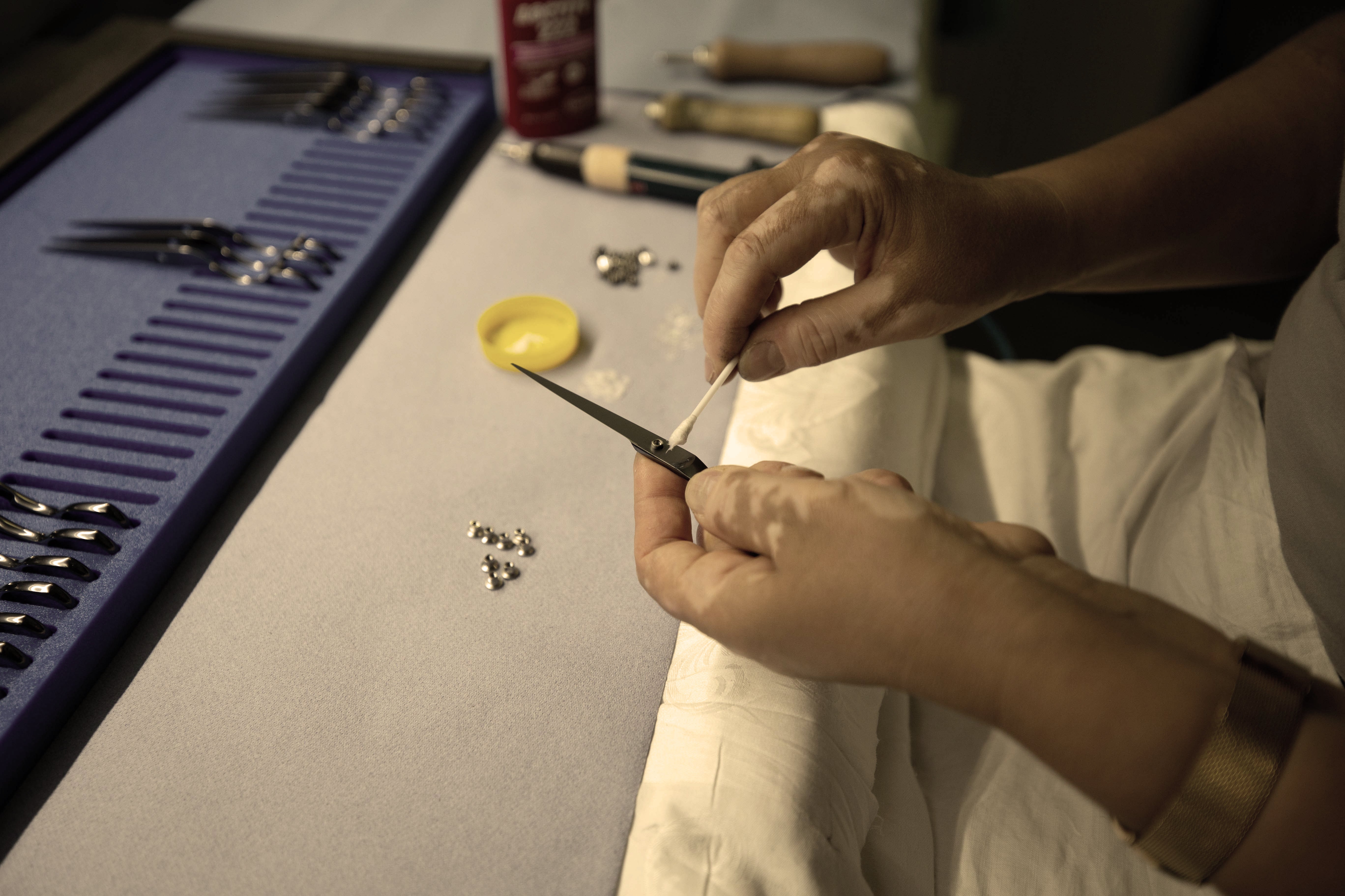 Hand reinigt hochwertige Friseurschere