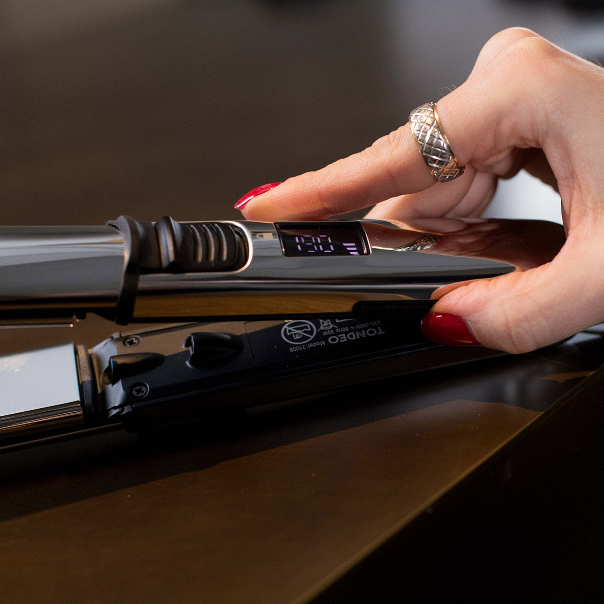 La mano ajusta el aparato de peluquería.