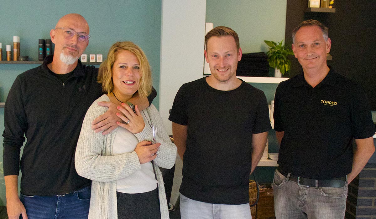 Vier Friseure mit Schere stehend