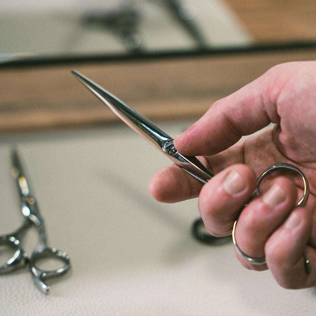 Hand hält hochwertige Friseurschere